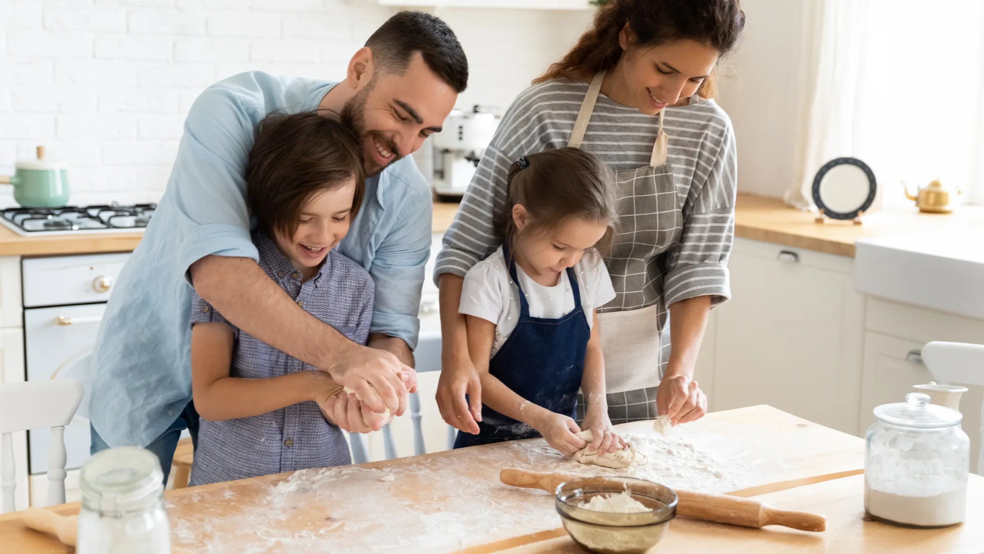 Familie backt gemeinsam Brot in heller Küche — die Küche als Mittelpunkt des Zuhauses
